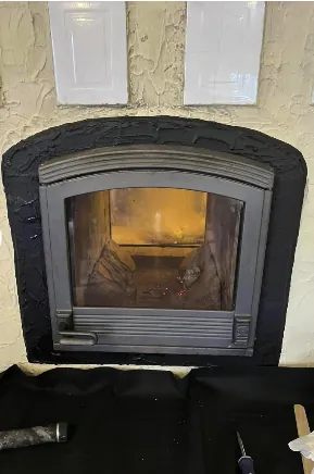 Modern glass-front insert installed in arched firebox