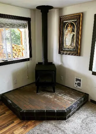 Finished corner wood stove install with tiled hearth