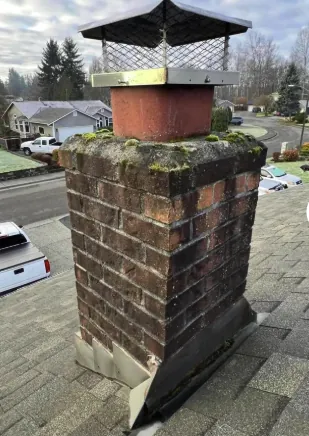 Weathered mossy brick chimney before restoration