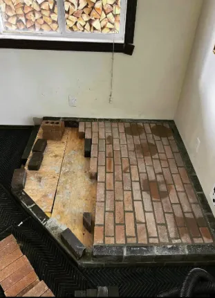 Old brick hearth torn out for stove installation