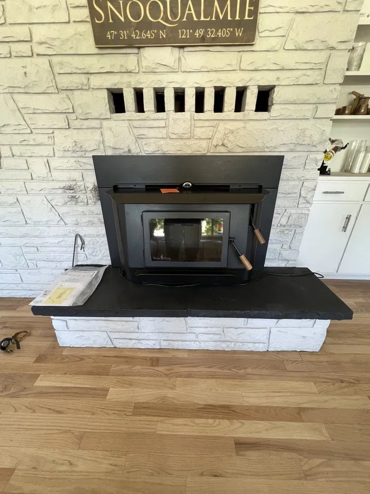 Snoqualmie wood stove installed in stone surround